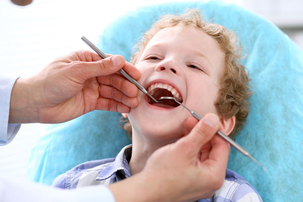 Стоматолог осматривает молочные зубы ребёнка.jpg