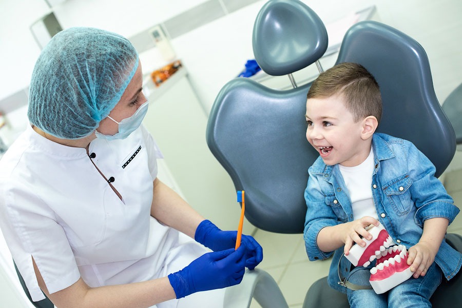 Стоматолог показывает маленькому ребёнку, как правильно чистить зубы.jpg